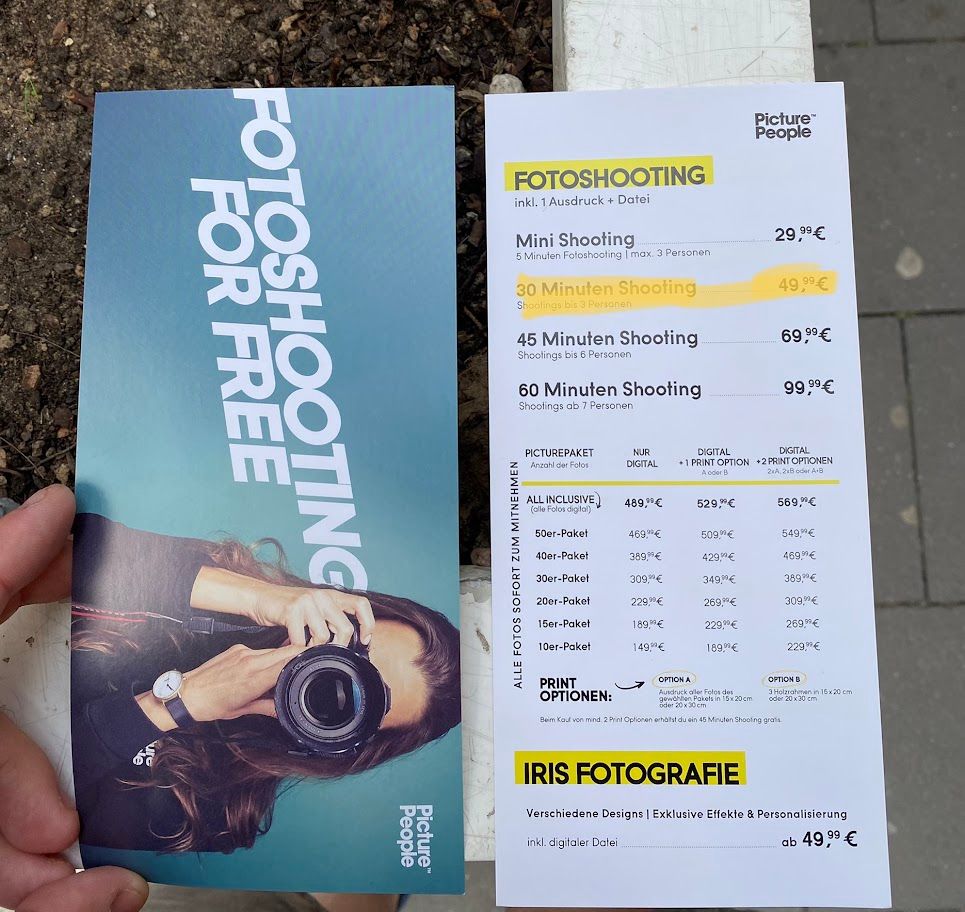 Gutschein mit langhaariger Person mit Kamera: "Fotoshooting Free - Picture People" Daneben Flyer mit Preisen. Markiert ist: "30 Minuten Shooting (bis 3 Personen) für 49,99€"